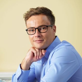 Smiling businessman in glasses sitting at table